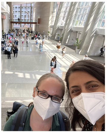 Heather and Gowri wear masks and smiling eyes at the Raleigh Conference Center at the Raleigh Conference Center