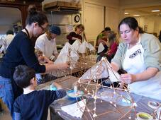 Community members build 3D luminaries from willow and paper during in a lantern making workshop